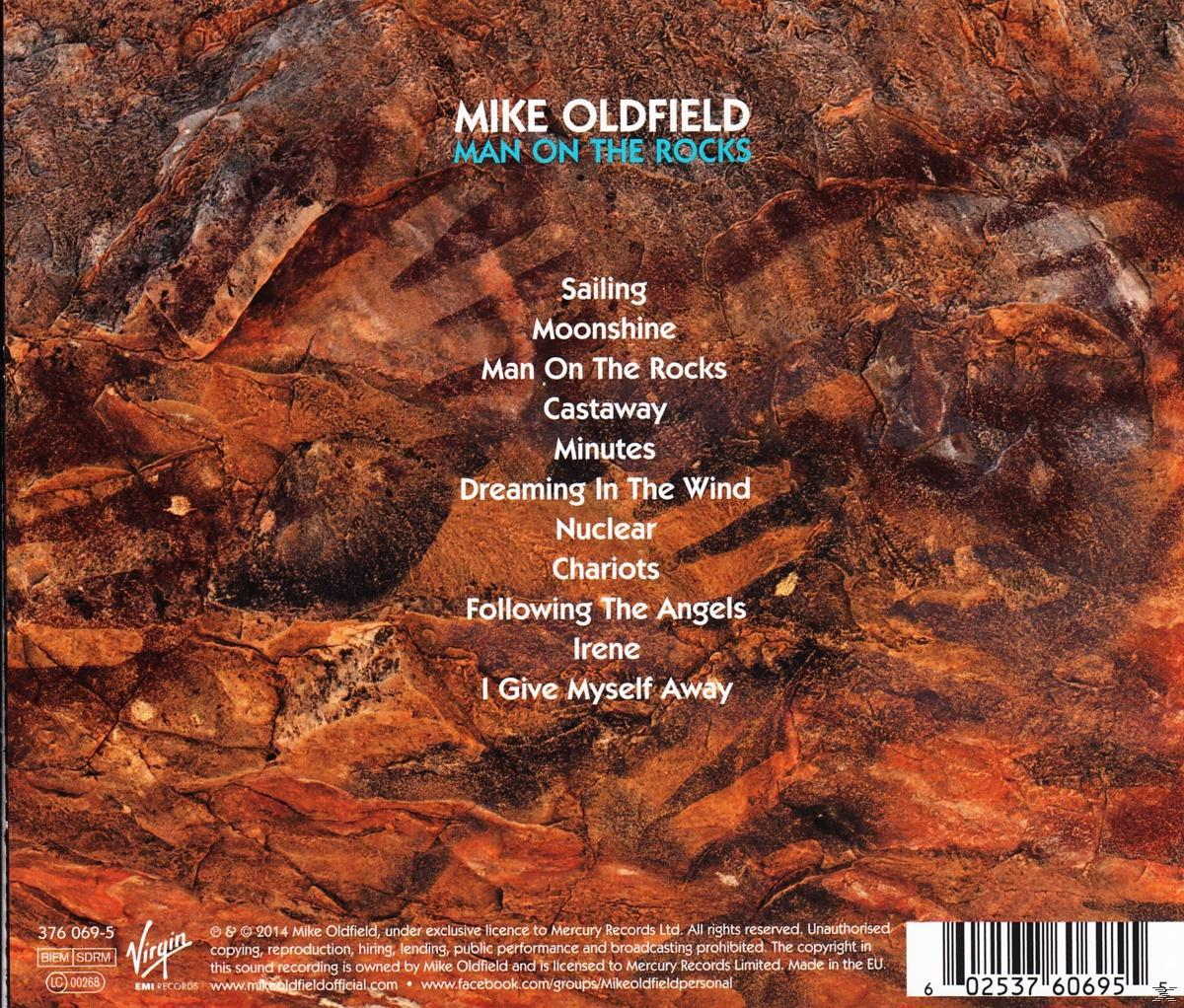 Albumcover mit Titel und Titelliste auf braunem, felsigem Hintergrund.