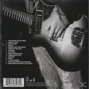 Achterkant van een cd-hoesje. Een persoon die gitaar speelt. Tracklist links. Bandnaam en logo rechts.