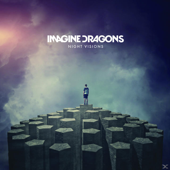 Pochette d'album : Imagine Dragons, Night Visions. Un homme debout sur des piliers hexagonaux, ciel en arrière-plan.