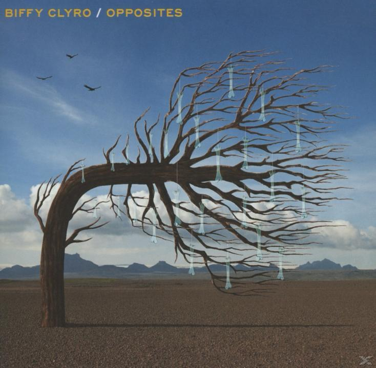 Albumcover: Ein Baum mit hängenden Objekten vor blauem Himmel und Bergen.