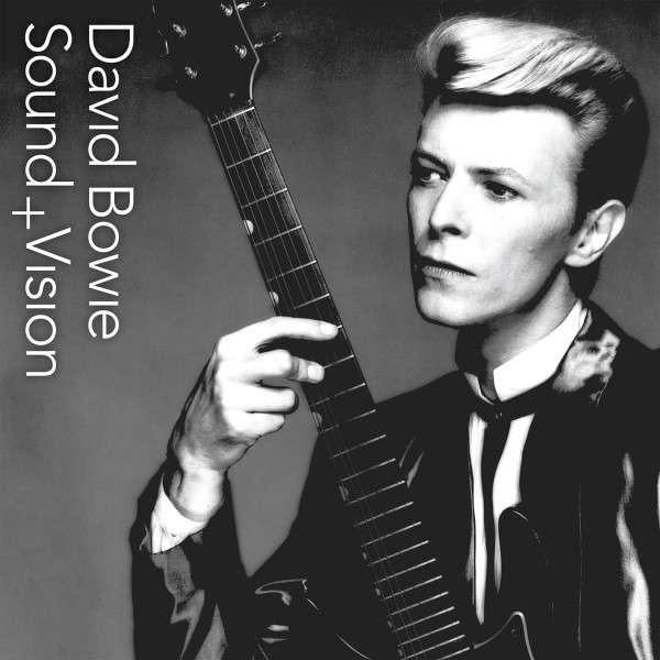 David Bowie gitárral, fekete-fehér fotó.