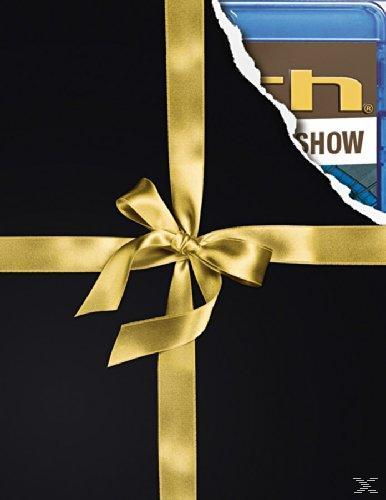 Ein verpacktes Geschenk mit goldenem Band, mit einem Blick auf eine blaue Geschenkkarte.