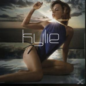 Kylie album borítója. Kylie ül, karját felemelve, kék fürdőruhában, egy strandon.