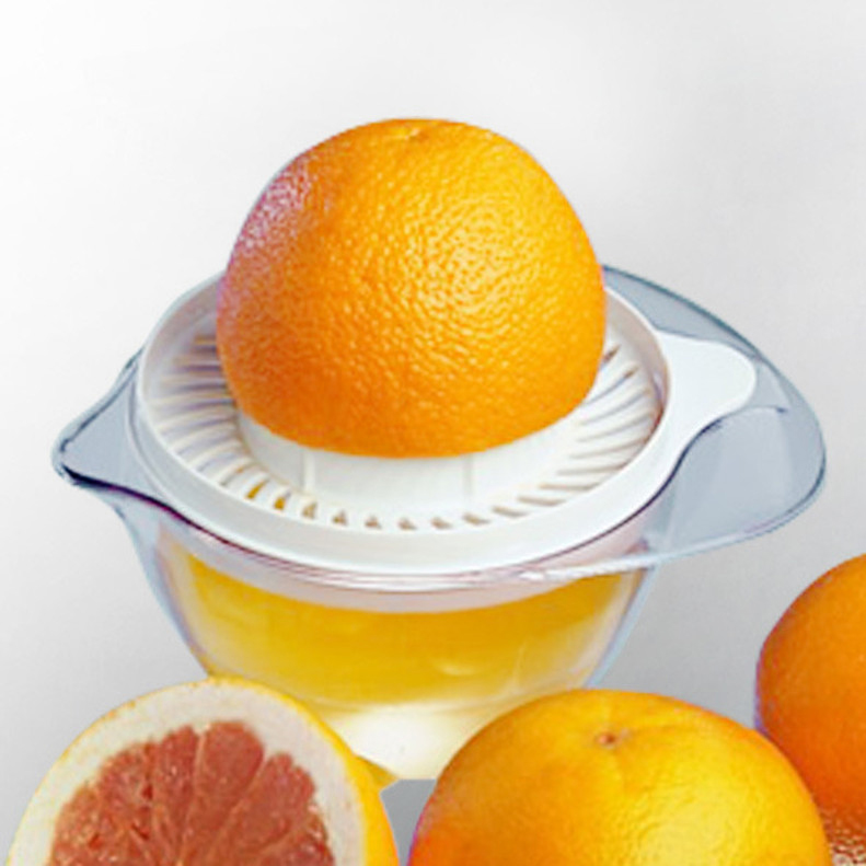 Eine Saftpresse mit Orange und Orangensaft. Eine Orange wird gepresst.