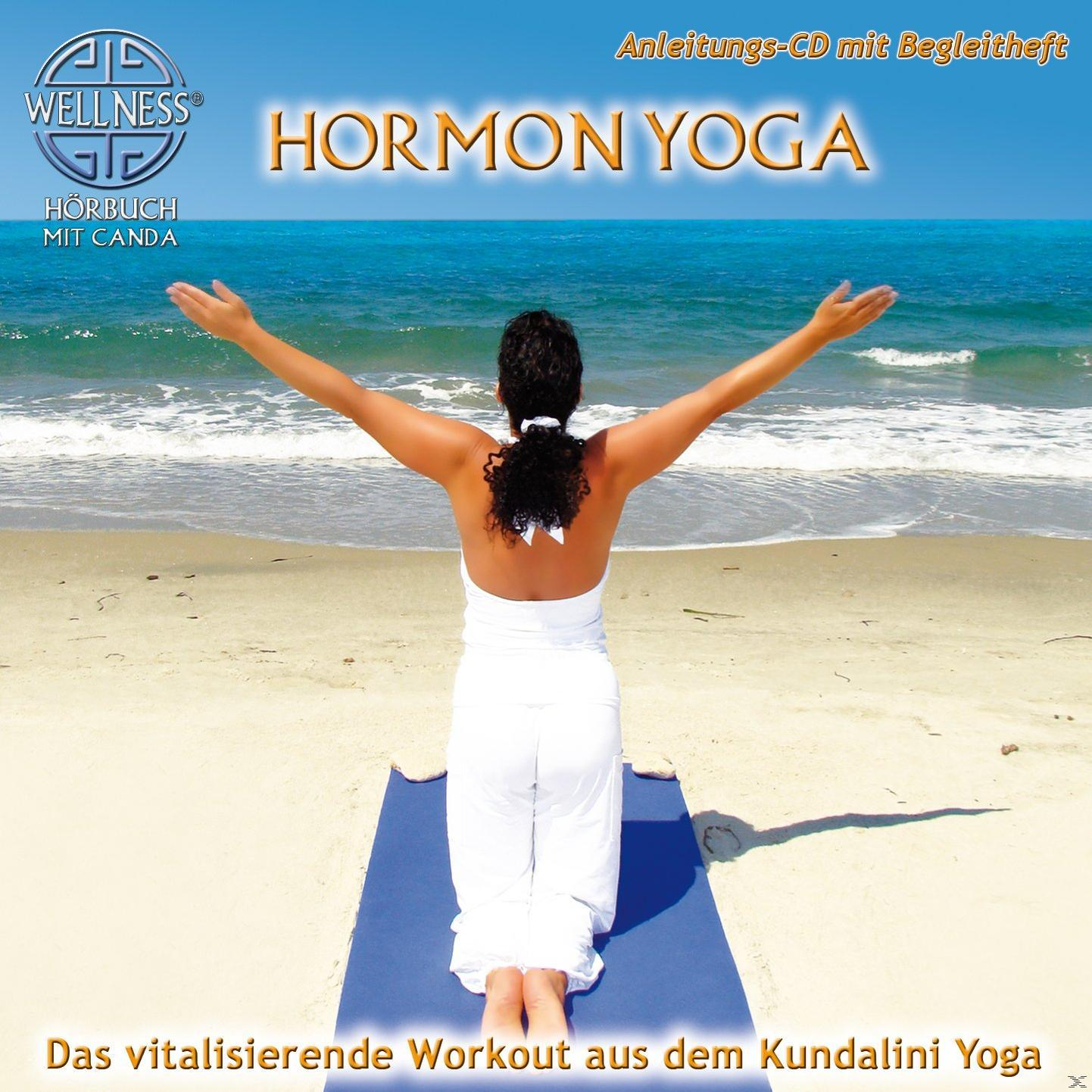 Frau in weißer Yoga-Pose am Strand, blaue Matte, Text 'Hormon Yoga', Wellness-Logo und Strandhintergrund.