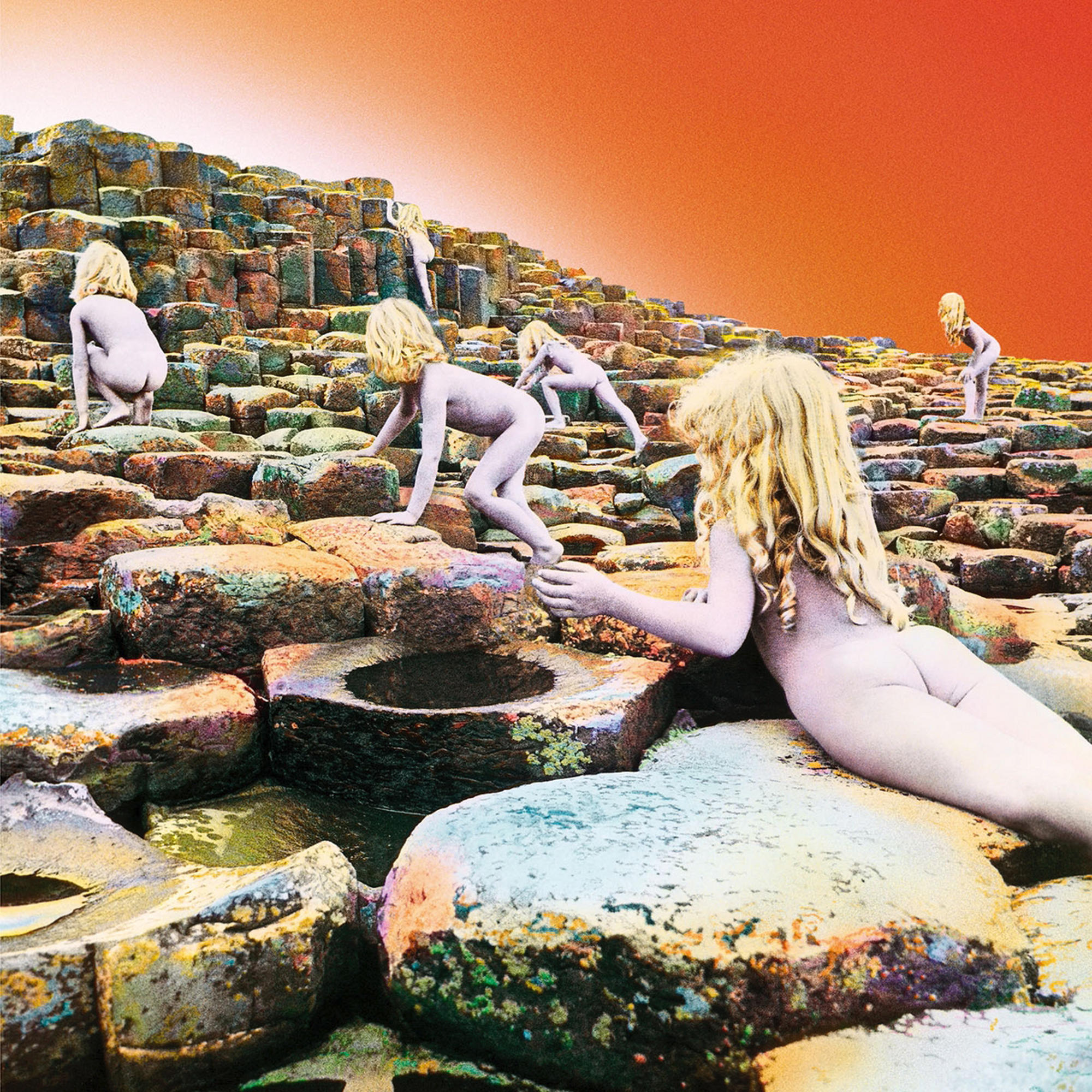 Albumcover: Mehrere nackte Kinder klettern auf Felsformationen mit einem orangefarbenen Himmel.