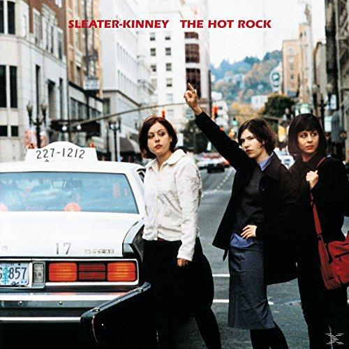 Albumcover mit drei Frauen, die auf einer Stadtstraße in der Nähe eines Taxis stehen.