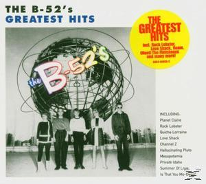Albumcover mit Globus und Figuren, plus gelber 'Greatest Hits'-Kreis.