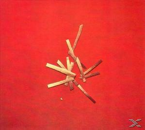Holzstäbe auf rotem Hintergrund verstreut. Einige sind hell, andere dunkel, bilden eine Ansammlung.
