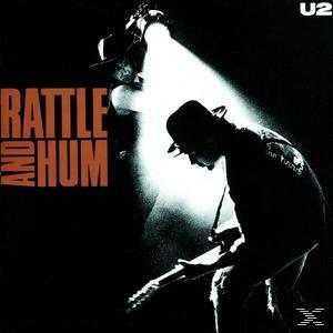U2 Rattle and Hum CD borítója. Két alak a színpadon, az egyik gitározik.