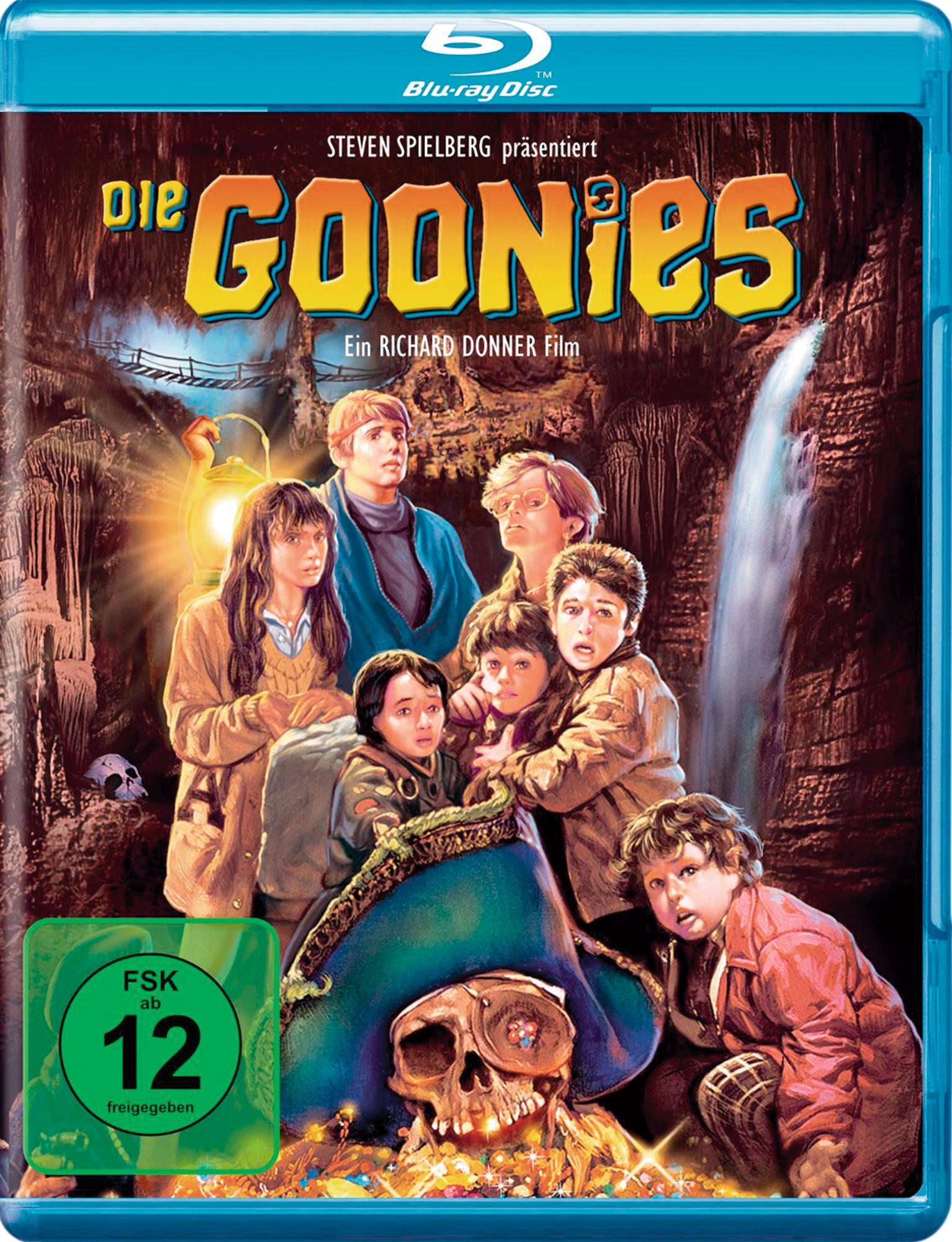 Filmcover: Kindergruppe mit Piratenschädel. Titel: Die Goonies. Höhlenhintergrund.