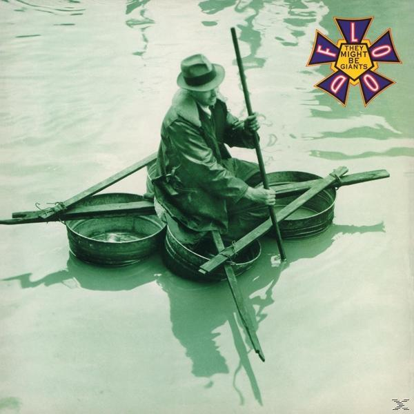 Mann in Hut und Mantel auf einem Fassfloß im Wasser, hält eine Stange. Das Logo von "They Might Be Giants" ist sichtbar.