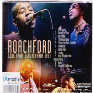Roachford Live Albumcover. Mann singt in ein Mikrofon, andere Musiker im Hintergrund.