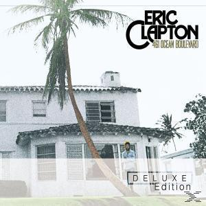Albumcover von Eric Clapton mit einem Haus, einer Palme und einem Mann davor.