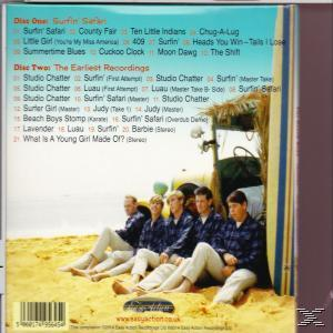 Cinq hommes en chemises et pantalons assortis sont assis sur une plage de sable à côté d'une cabane en paille, à côté d'un étui de CD.