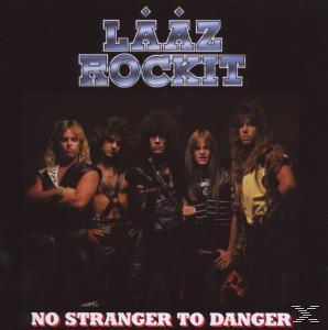 Fünf Männer in Bandkleidung posieren für ein Albumcover im Stil der 80er.
