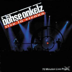 Konzertfoto mit Bühnenlicht und Silhouetten. Band auf der Bühne, Zielscheibe im Zentrum. 'Böhse Onkelz'.