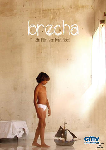 Ein Junge in weißer Unterwäsche steht an einer Wand, ein Spielzeugboot auf dem Boden.