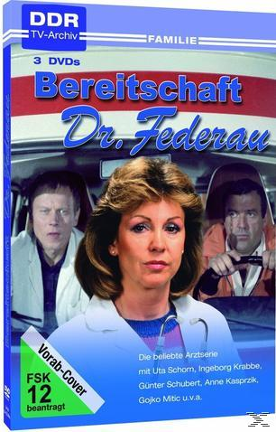 DVD-Cover von 'Bereitschaft Dr. Federau'. Drei Schauspieler in einer medizinischen Szene. Blaue und rote Farben.