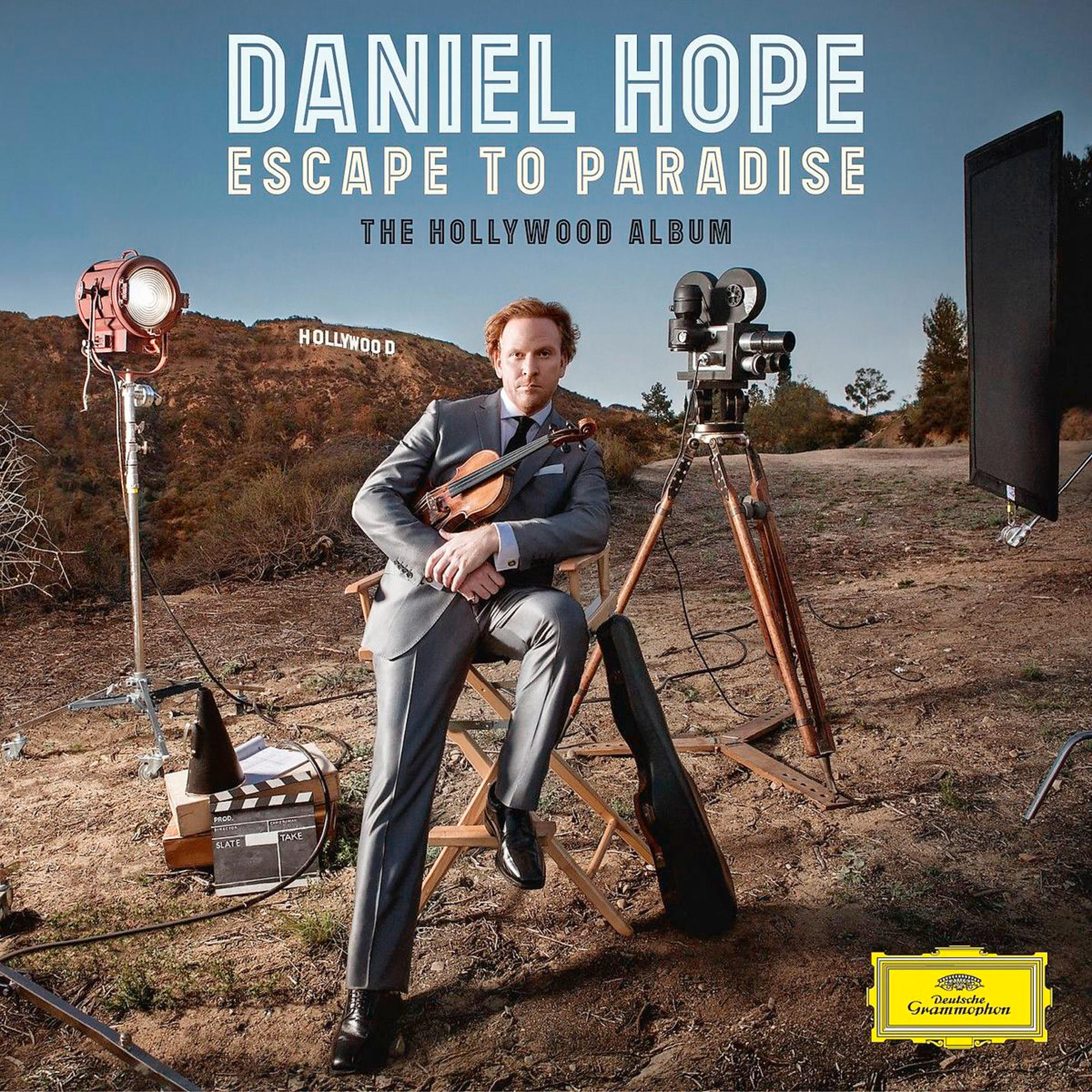 Albumcover. Mann im Anzug mit Geige, Hollywood-Hintergrund, Filmausrüstung und Titeltext.