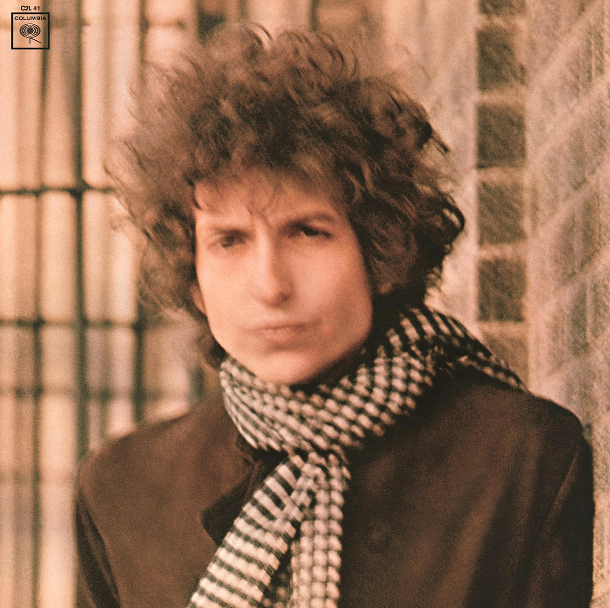 Bob Dylan album borító. Közelkép az arcáról. Sál, sötét kabát, göndör haj. Columbia címke.