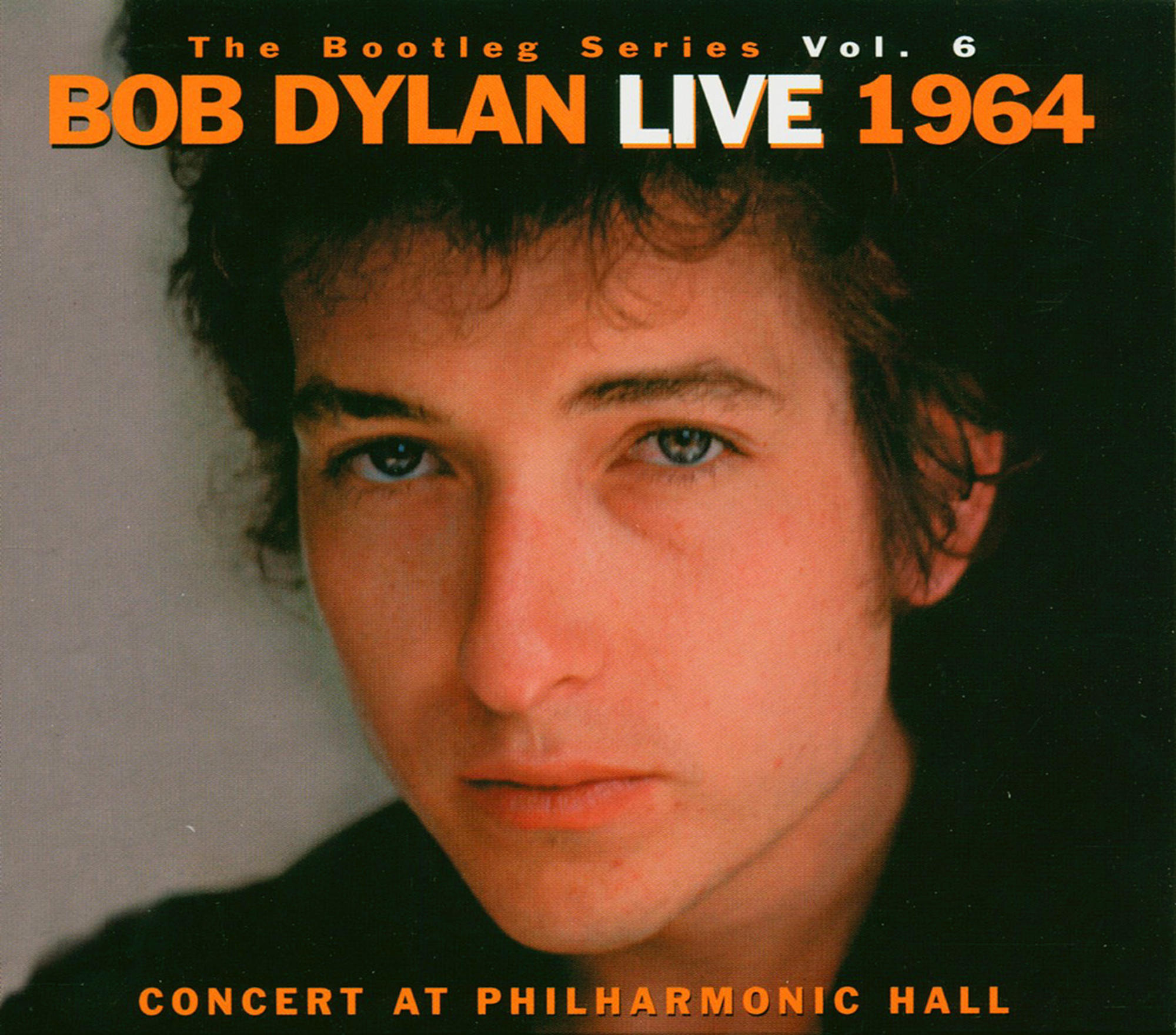 Albumcover mit Bob Dylans Porträt. Text auf orangefarbenem Hintergrund. Konzert in der Philharmonic Hall.