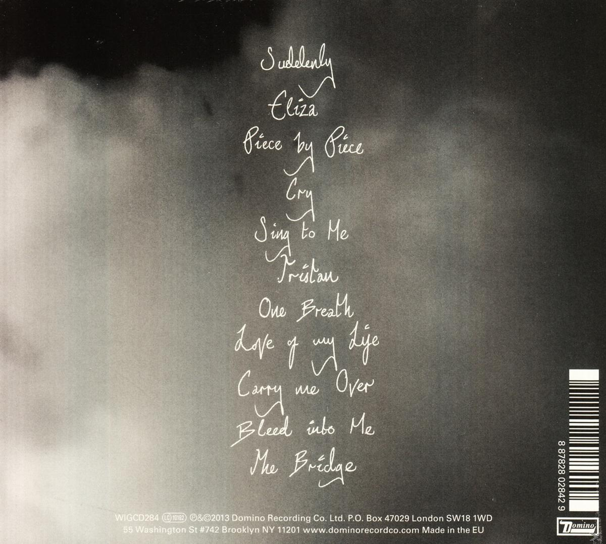 CD-Rückseite mit Songtiteln in weißem Text vor verschwommenem, grauem Hintergrund.