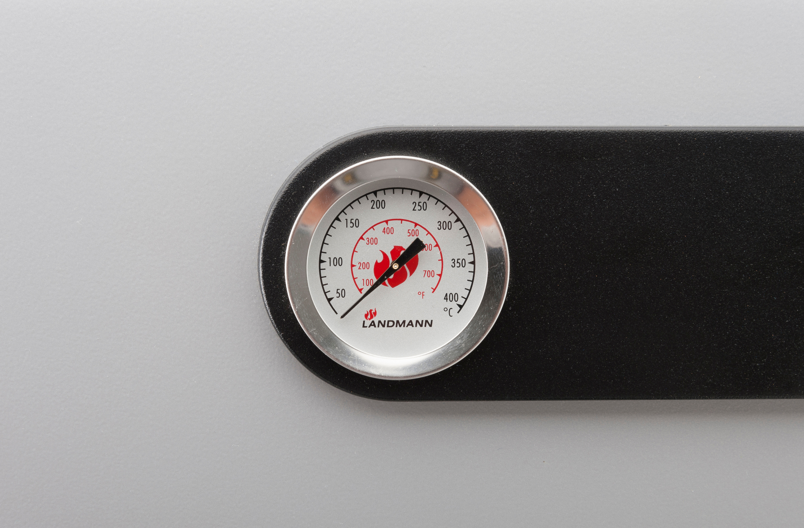 Nahaufnahme eines Thermometers auf grauer Oberfläche, das die Temperatur anzeigt.
