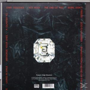 Albumcover mit einem großen, reflektierenden Diamanten in der Mitte, umgeben von roten Titeln.