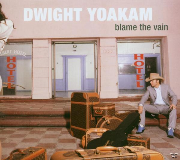 Album borító Dwight Yoakam-mal, bőröndökkel és egy szállodával. A cím: 'Blame The Vain'.