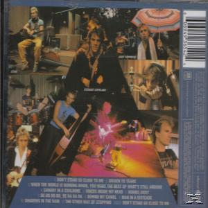 CD-Rückseite: Verschiedene Bandmitglieder auf der Bühne, Titelliste unten.