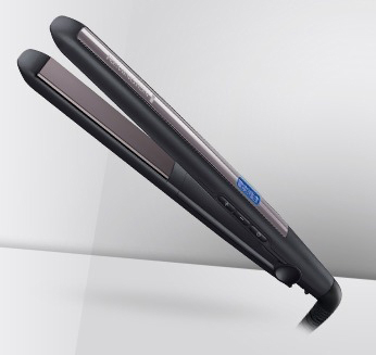 Een zwarte en zilveren Remington stijltang. Schuine weergave, witte achtergrond, modern design.