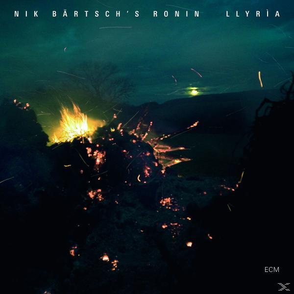 A 'Nik Bärtsch's Ronin - Llyria' album borítója. Absztrakt sötét jelenet tűzzel és sötétkék égbolttal.
