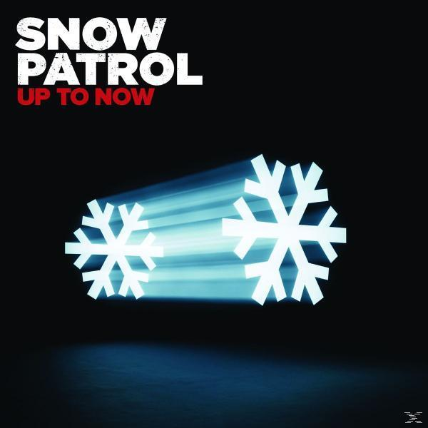 Flocons de neige avec des traînées lumineuses sur fond noir. Texte : SNOW PATROL, UP TO NOW.