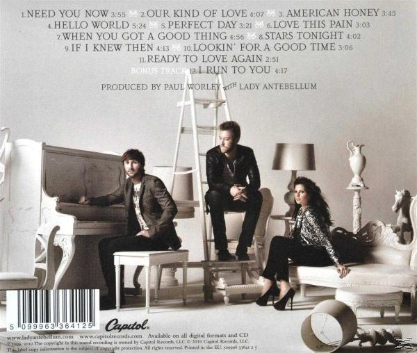 CD-Cover mit einer Band auf einer Bühne. Drei Leute, Klavier, Leiter. Weißer Hintergrund.