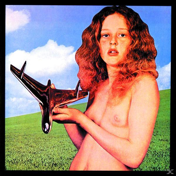 Albumcover mit einer nackten Frau, die ein Modellflugzeug auf einem grünen Feld hält.