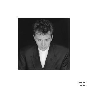 Foto von Peter Gabriel in Schwarzweiß, mit Anzug. Er blickt nach unten.