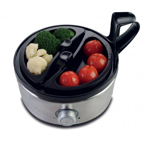 Un cuiseur d'œufs. À l'intérieur se trouvent des tomates et du brocoli. Le cuiseur est argenté avec une poignée et un couvercle noirs.