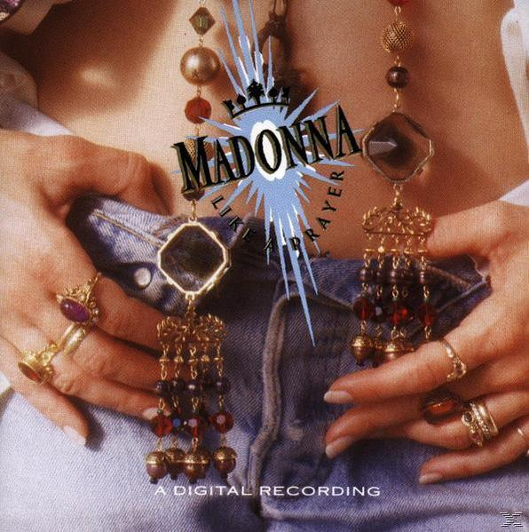 Madonna Albumcover, Hände halten geschmückte Halsketten und Ringe. Titeltext ist sichtbar.