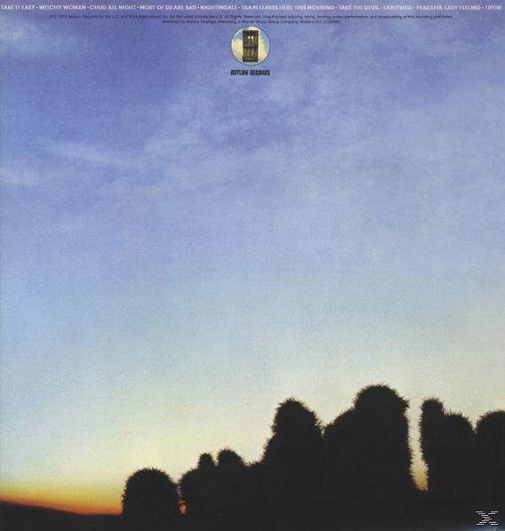 Albumcover mit Himmel, Wolken und Silhouetten von Bäumen.