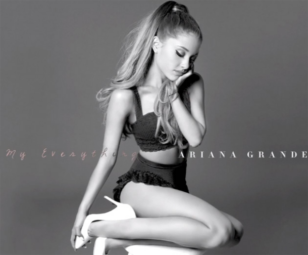 Ariana Grande en noir et blanc, posant dans une tenue deux pièces et des talons hauts.
