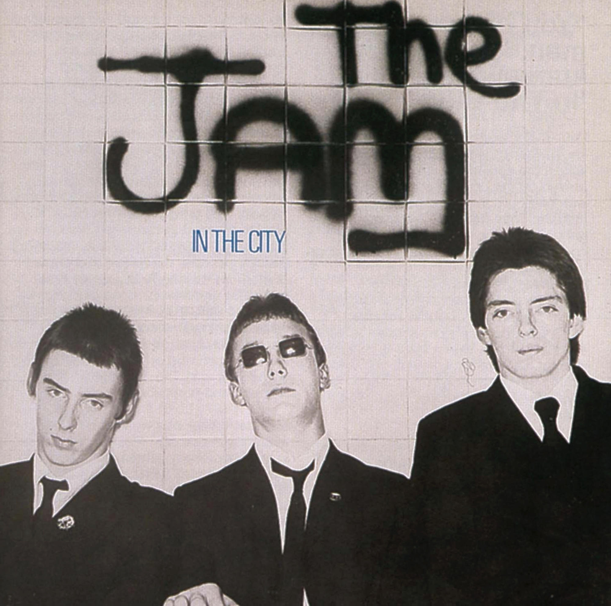 Albumcover: 3 Männer in Anzügen. Graffiti: The Jam, In The City.