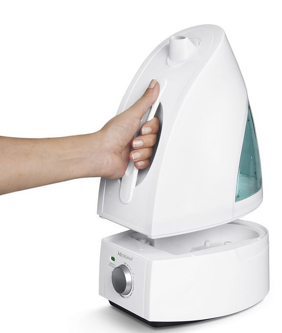 Un humidificateur blanc avec une main tenant le dessus, fond blanc.