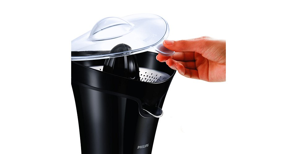 Une main ouvre un couvercle transparent sur une centrifugeuse Philips noire.