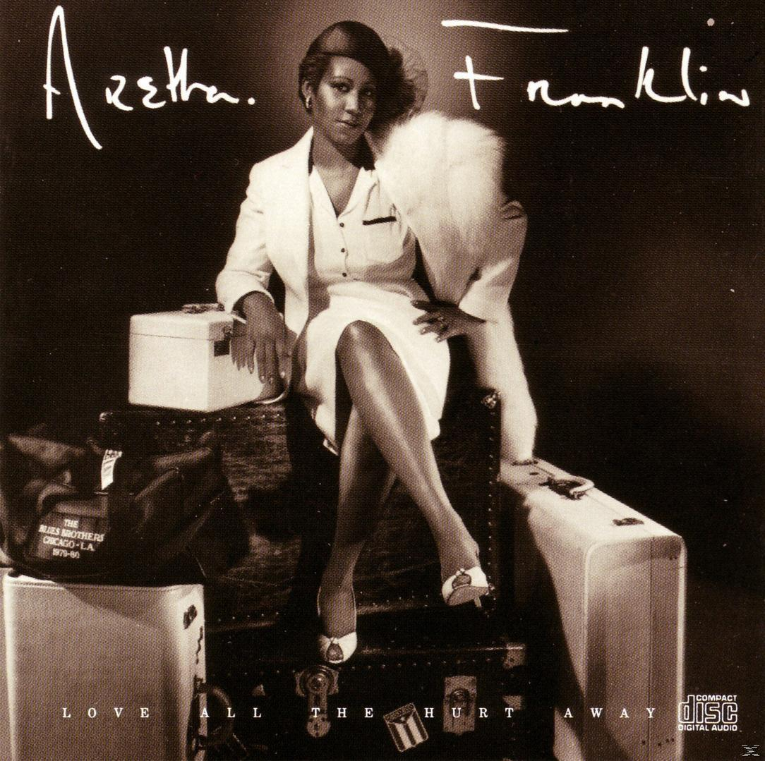 Aretha Franklin album borítója. Leült, fehér ruhában, egy bőrönddel a közelben.