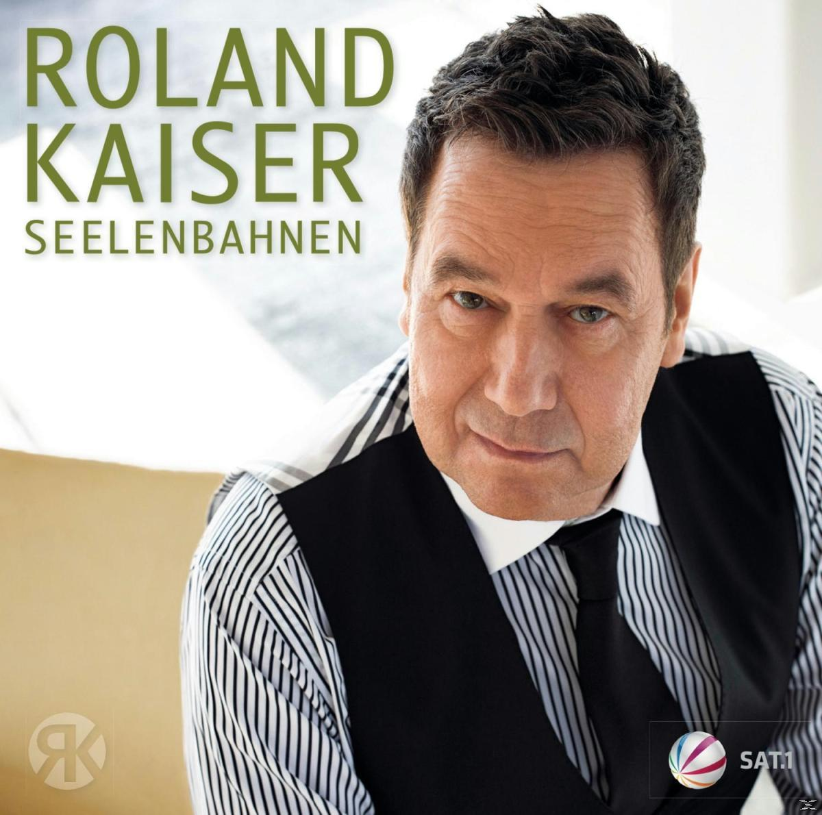 Roland Kaiser Albumcover. Mann in schwarzer Weste und gestreiftem Hemd, blickt den Betrachter an.
