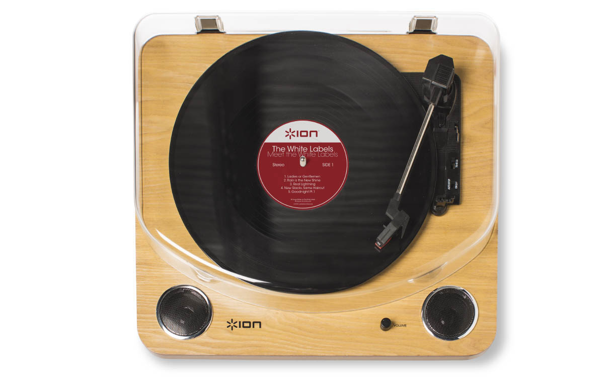 Une platine vinyle avec un disque en cours de lecture, avec un couvercle transparent et une base en bois.