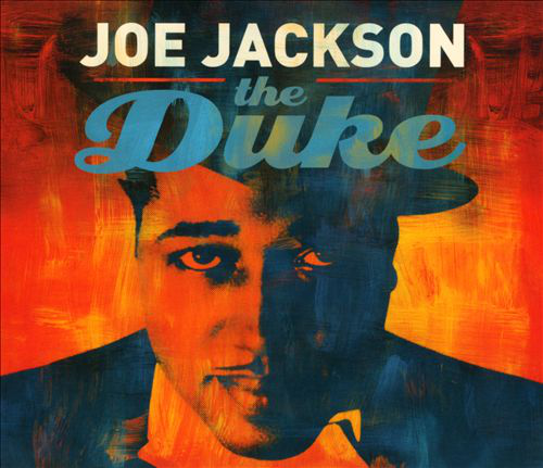Joe Jackson "The Duke" című albumának borítója. Egy kalapot viselő férfi stilizált portréja. Vastag szöveg piros és narancssárga hátéren.