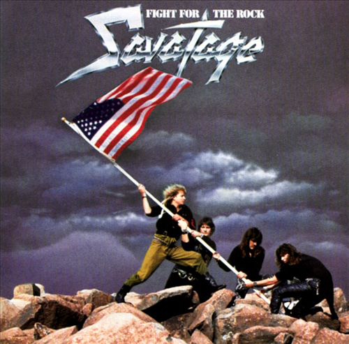Album borító egy bandával zászlóval. Szöveg: FIGHT FOR THE ROCK. Sötét, felhős égbolt háttér.
