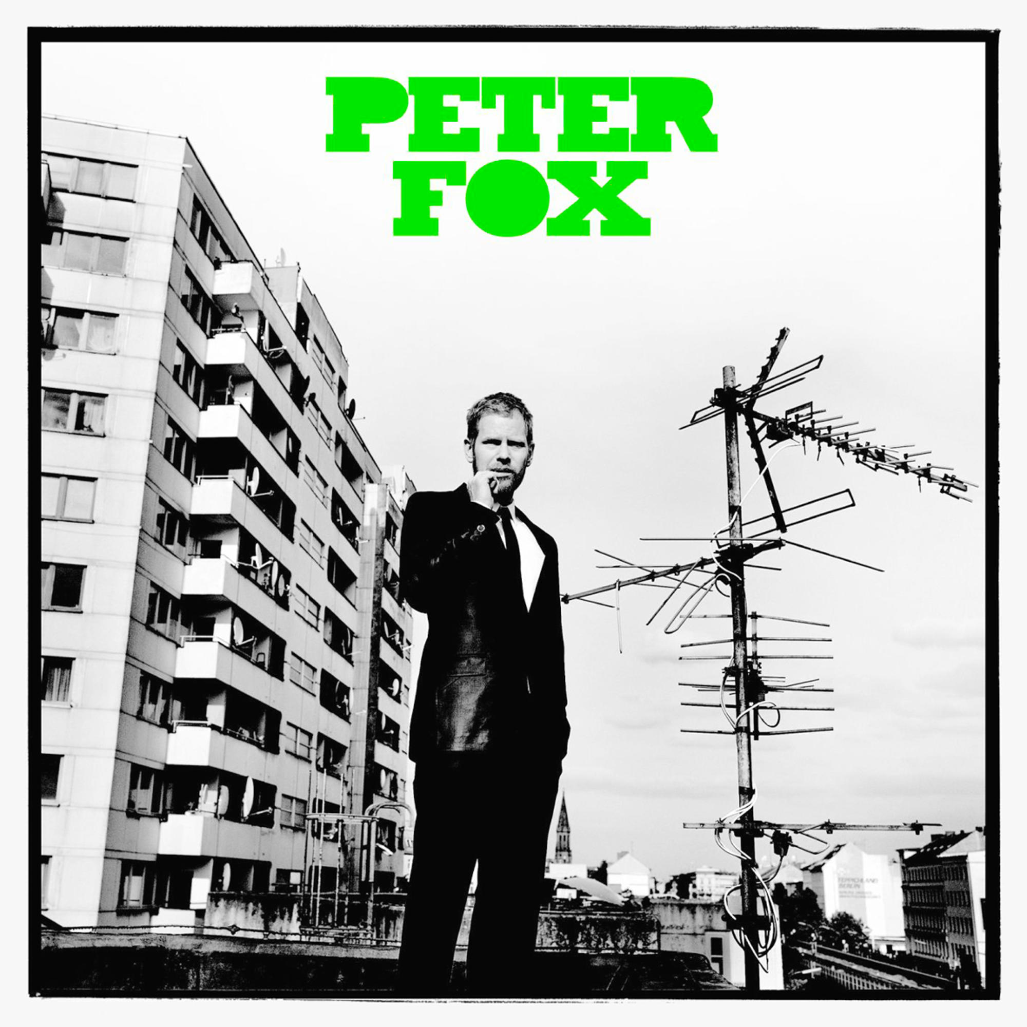 Albumcover von Peter Fox, schwarzer Anzug, auf dem Dach stehend. Grüner Text.